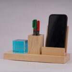 A Pen holder with two pens and a slot for a mobile phone with a crystal cube