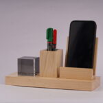 A Pen holder with two pens and a slot for a mobile phone with a crystal cube