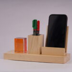 A Pen holder with two pens and a slot for a mobile phone with a crystal cube