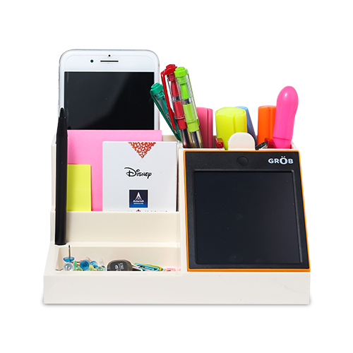 A Pen holder with few pens and a slot for a mobile phone with another compartment for stationary items