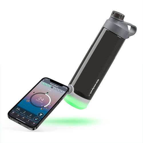 HidrateSpark tap bottle is lying horizontally next to a smartphone
