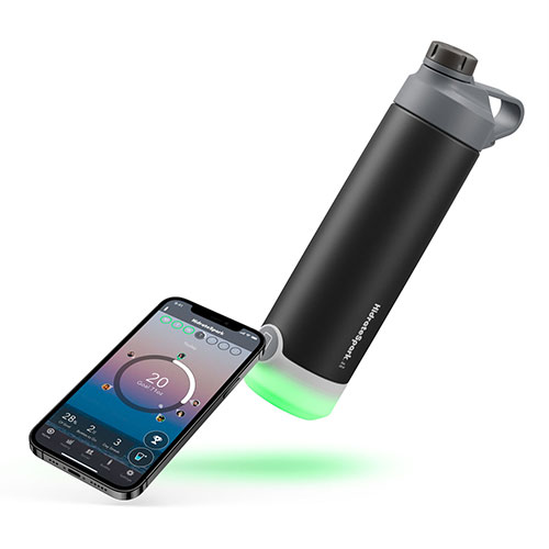 HidrateSpark tap stainless steel bottle is lying horizontally next to a smartphone
