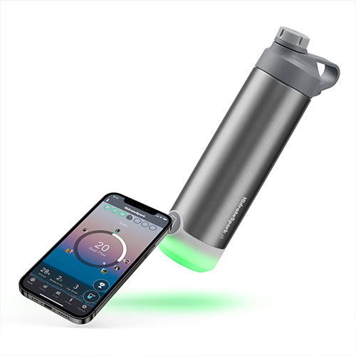 HidrateSpark tap stainless steel bottle is lying horizontally next to a smartphone